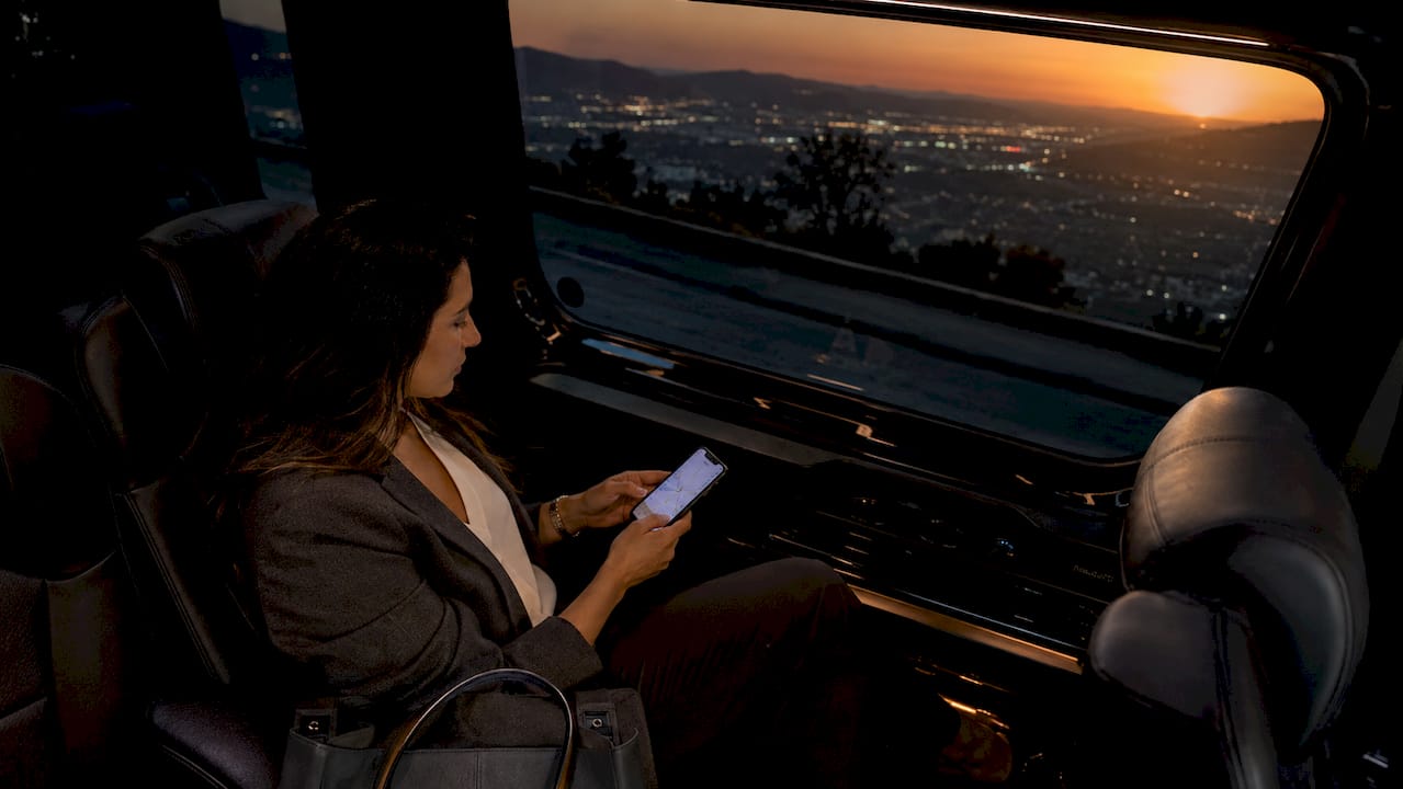 Traveler using phone navigation inside minivan