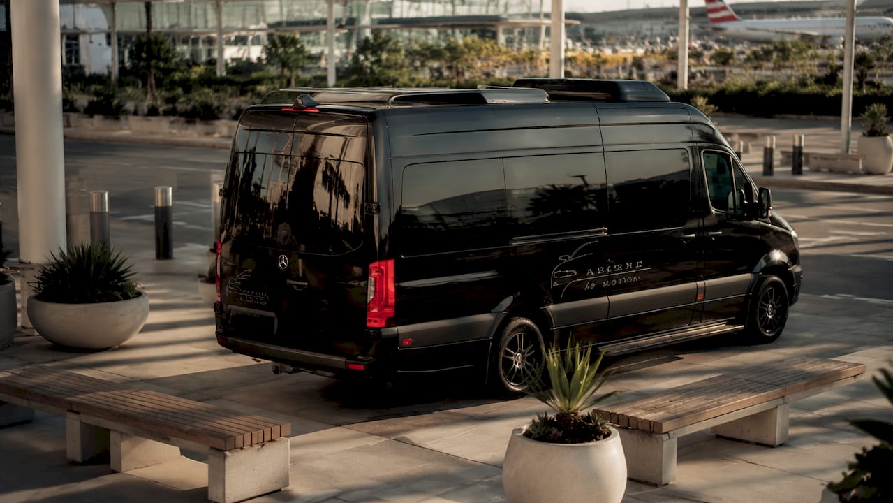 Ascend branded black Mercedes Sprinter at airport curb