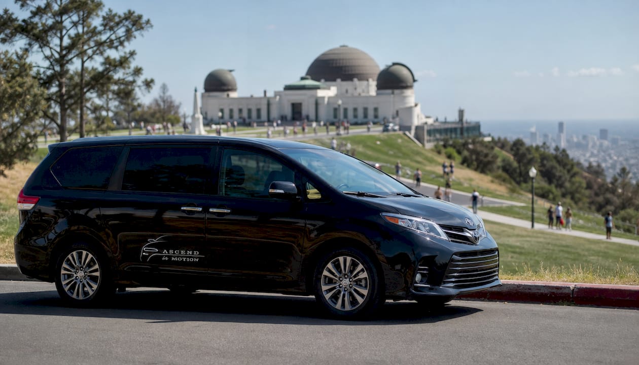 Black branded Ascend in Motion minivan at LA museum entrance