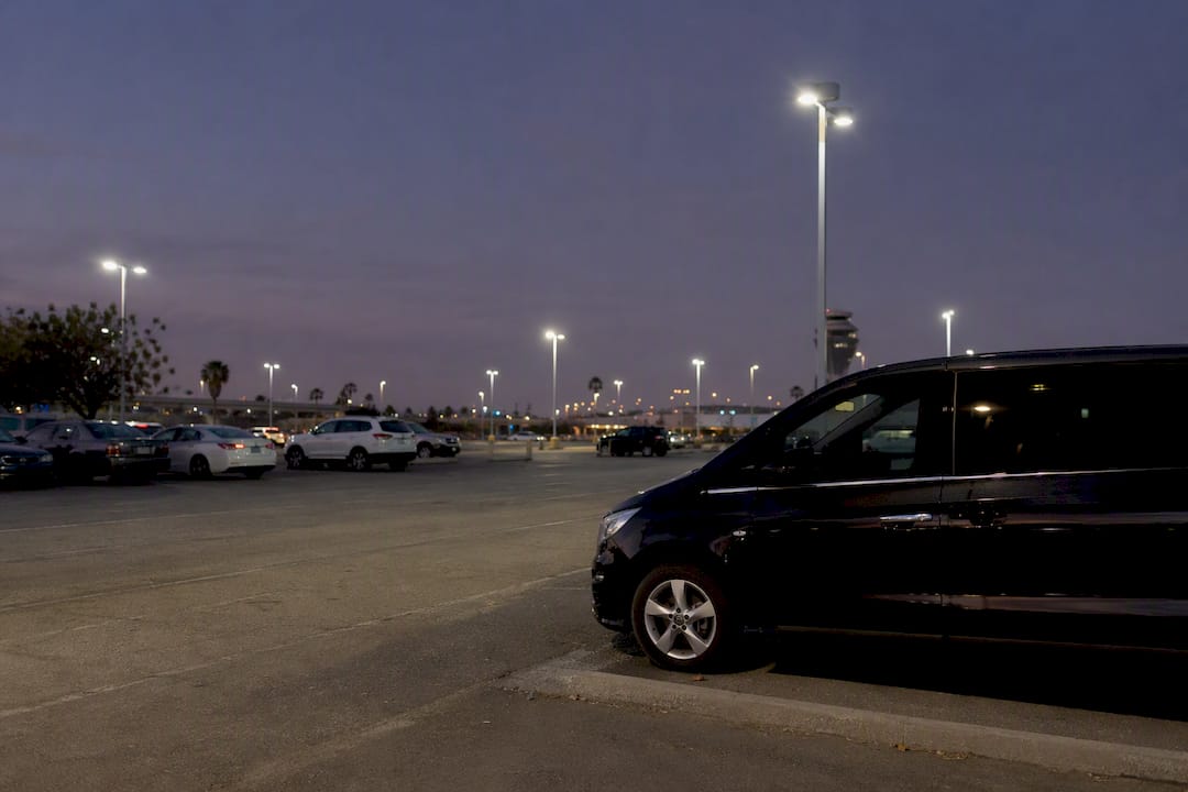 Nighttime LAX cell-phone lot with parked minivan