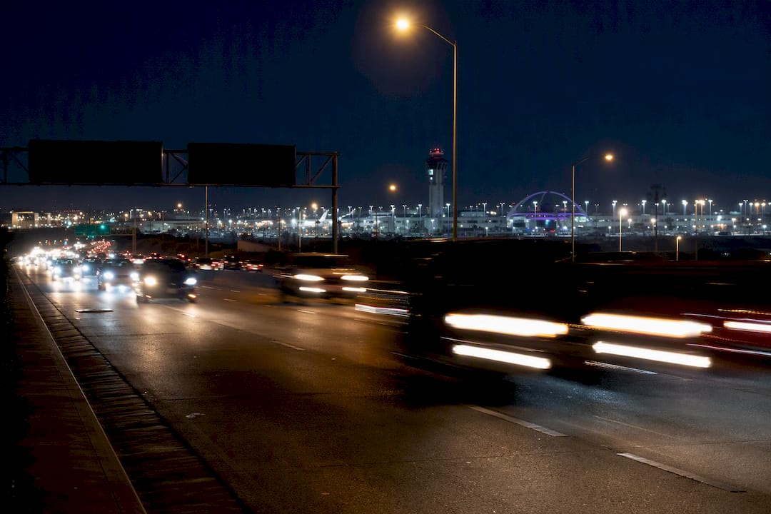 Empty freeway with car light trails at night near LAX