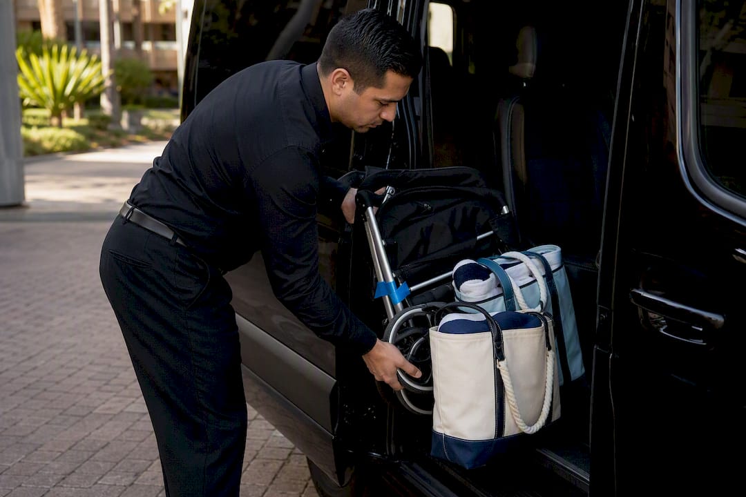 Chauffeur loading stroller and beach bags
