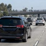 Branded minivan traveling toward Anaheim in freeway traffic